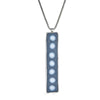 7 Dots Necklace Ronnie Taubenfeld is a long silver rectangular pendant with white glass dots on a gray resin background