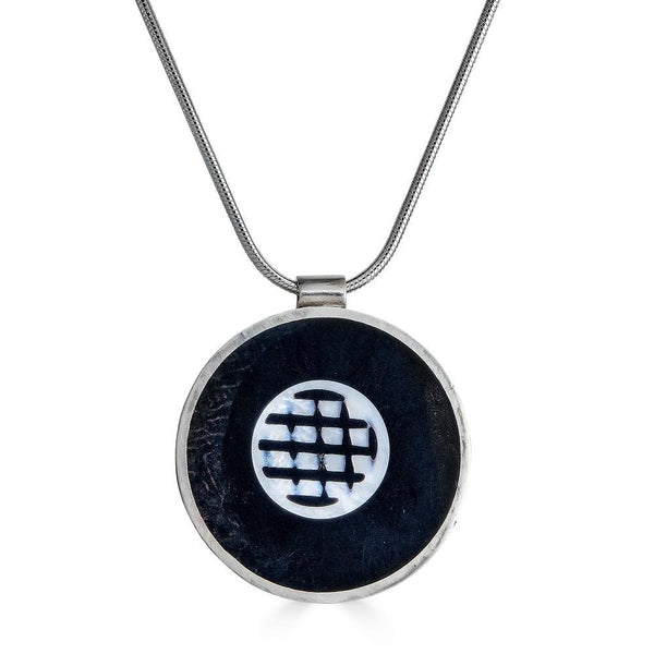 Beyond the Screen Necklace Ronnie Taubenfeld is a handmade round silver pendant with a mother of pearl shape set in black resin