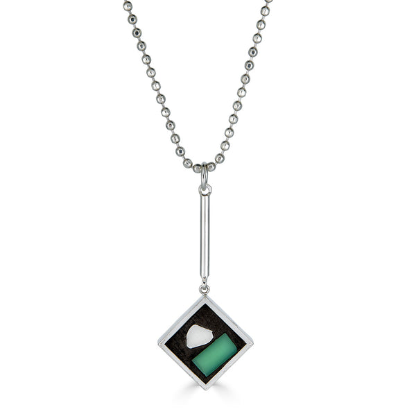 Point of View Pendant by Ronnie Taubenfeld is handmade with turquoise glass and silver shapes embedded in black resin set in a square sterling silver frame suspended from a silver ball chain.