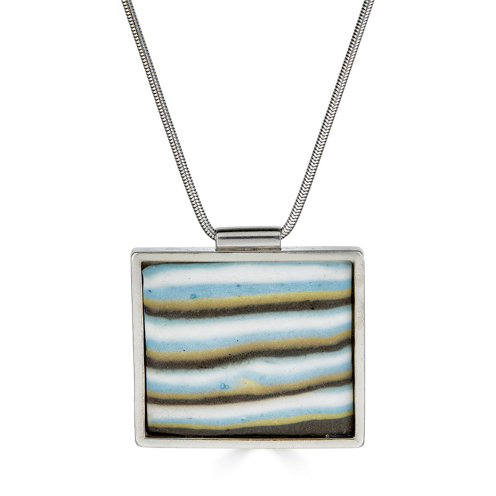 Ofek Pendant by Ronnie Taubenfeld is a handmade porcelain tile set in sterling silver frame hanging from a silver snake chain.