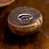 Chirip Ring Ronnie Taubenfeld displayed on a carved wooden object
