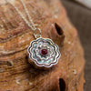 Colorful Zinnia Necklace Ronnie Taubenfeld is handmade using carved mother of pearl with Garnet cabochons set front and back and framed in sterling silver