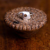 Fogo Ring Ronnie Taubenfeld shown on carved wooden object