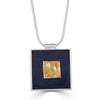 Portrait of a Gold Square Necklace by Ronnie Taubenfeld is handmade using a square 24K gold fused glass smalto embedded in black resin and set in a square silver frame, suspended from a silver snake chain.