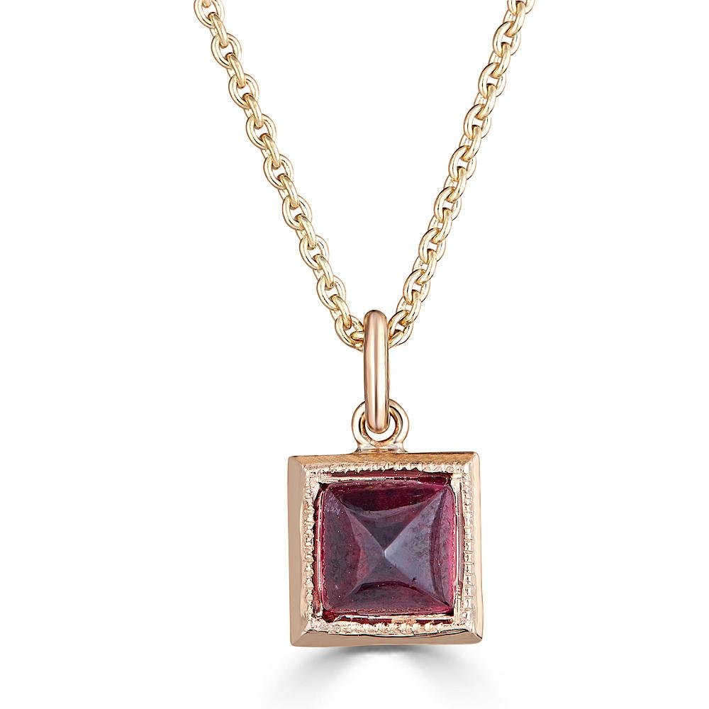 Pyramid Power Necklace by Ronnie Taubenfeld is a tiny pyramid-cut Garnet gem set in a 14K gold square setting with a cutout flower on the reverse side, hanging from a gold cable chain.