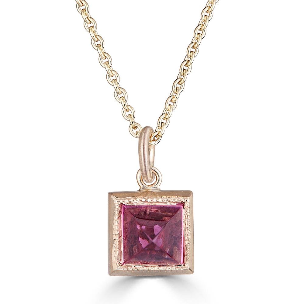 Pyramid Power Necklace by Ronnie Taubenfeld is a tiny pyramid-cut Pink Tourmaline gem set in a 14K gold square setting with a cutout flower on the reverse side, hanging from a gold cable chain.