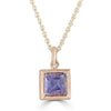 Pyramid Power Necklace by Ronnie Taubenfeld is a tiny pyramid-cut lavender Iolite gem set in a 14K gold square setting with a cutout flower on the reverse side, hanging from a gold cable chain.