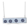 Rolling Bullseye Necklace by Ronnie Taubenfeld  is a silver horizontal bar pendant with glass bullseye slices of black and white embedded in a dove gray resin background suspended from a silver cable chain.