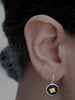 Square in a Circle Drop Earrings by Ronnie Taubenfeld shown hanging from a woman's ear.