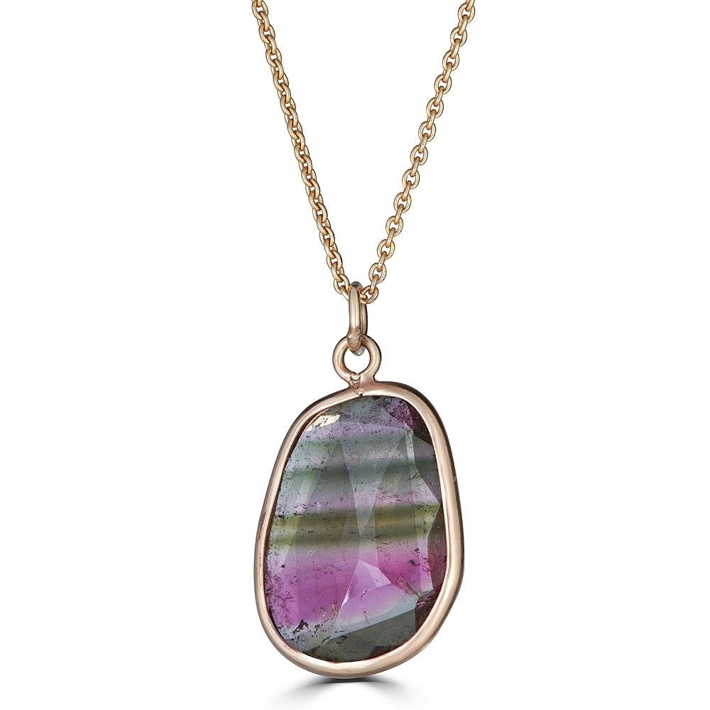 Striped Gem Necklace by Ronnie Taubenfeld is a striped Watermelon Tourmaline faceted oval gem channel set in 14K yellow gold, hanging from a gold cable chain.