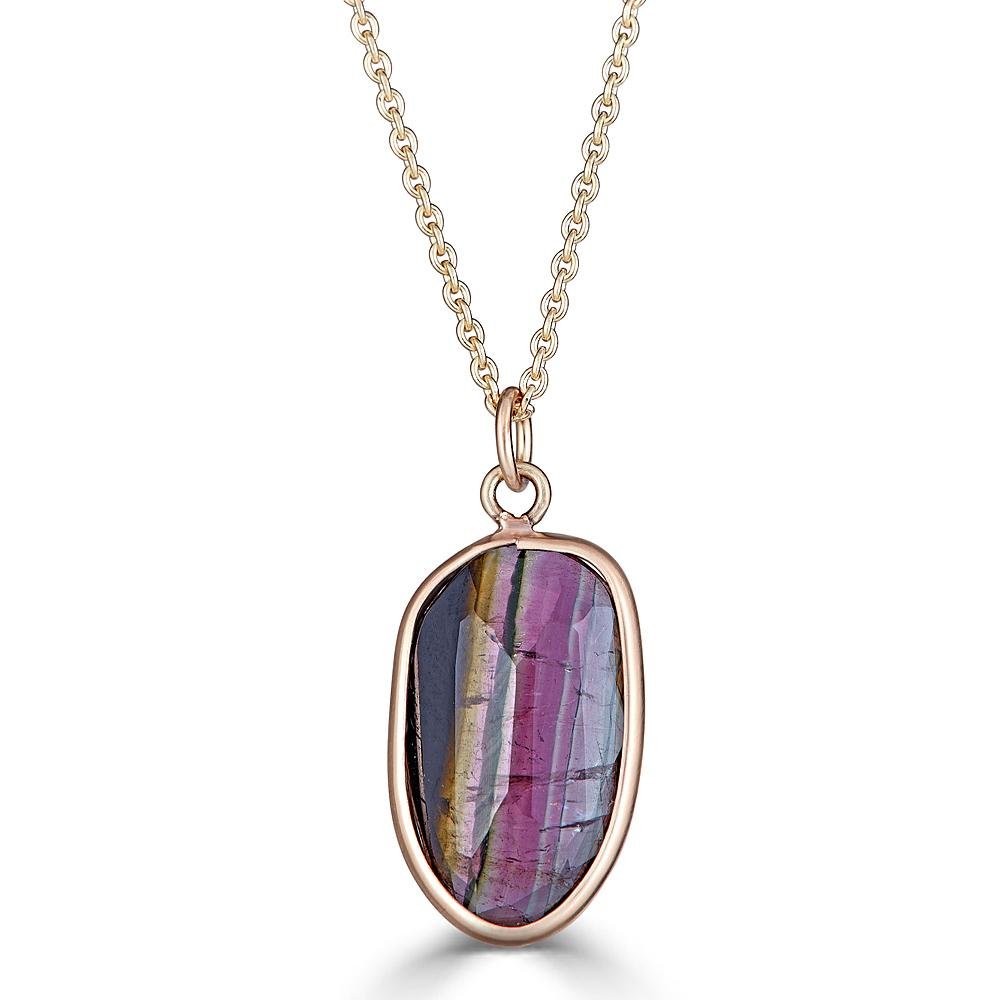 Striped Tourmaline Necklace by Ronnie Taubenfeld is a striped Watermelon Tourmaline faceted oval gem channel set in 14K yellow gold, hanging from a gold cable chain.