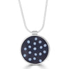 Tiny Dots Necklace by Ronnie Taubenfeld is an irregular grid of tiny white glass dots sprinkled in black resin and set in a circular sterling silver setting, hanging from a sterling silver snake chain.
