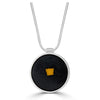 Tiny Fragment Necklace by Ronnie Taubenfeld is a tiny yellow square of Murano glass embedded in black resin and set in a circular sterling silver frame, hanging from a silver snake chain.